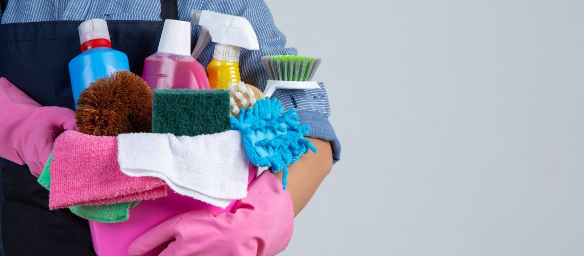 woman-is-holding-cleaning-product-gloves-rags-basin-white-wall (1)